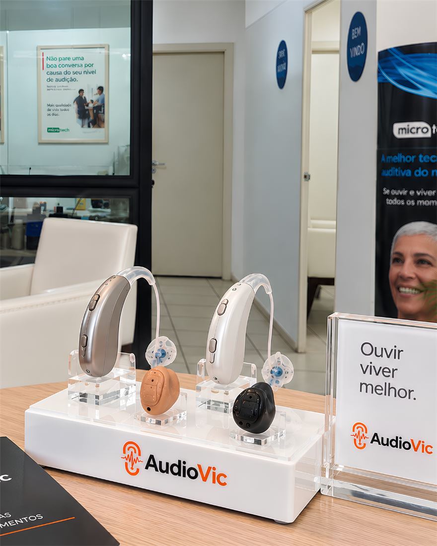 Expositor da AudioVic com quatro tipos de aparelho auditivo lado a lado